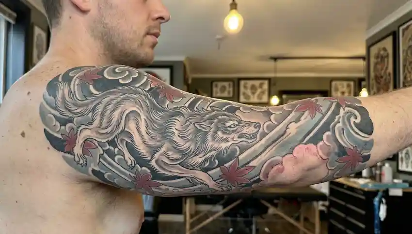Japanese wolf tattoo on a man’s upper arm and shoulder